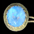 Copper alloy button setting with a bright blue ovoid faceted inset. The scalloped edge of the setting holding the inset and the oval shape are characteristics that appeared in the second half of the 18th century.